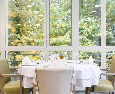 Tables rondes dressées et décorées avec soin offrant vue sur jardin